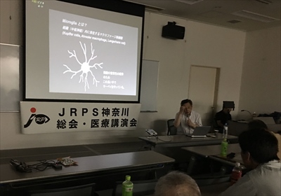 スライドを使って講演している写真です