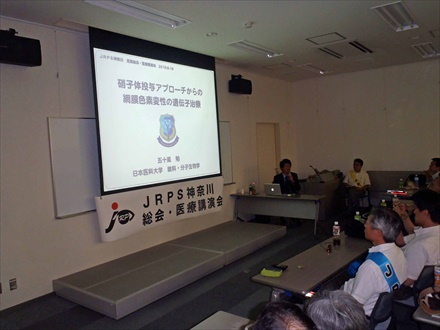 スライドを使って講演している写真です